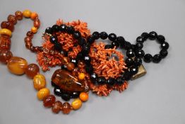 Four assorted necklaces including amber and coral, an amber pendant and a yellow metal locket (a.