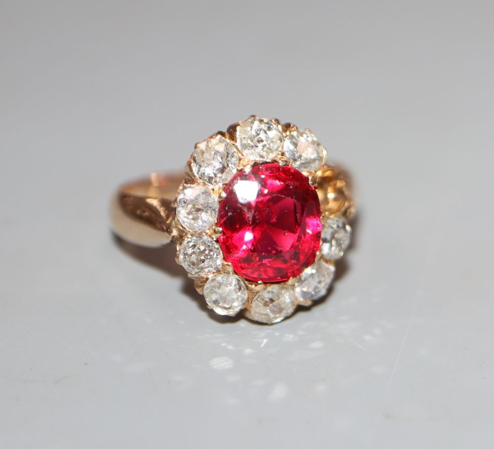 An early-mid 20th century yellow metal, red doublet and diamond set oval cluster ring, size K, gross