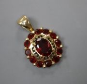 A modern 585 and garnet set oval cluster pendant, 16mm, gross 3.6 grams.CONDITION: Overall good