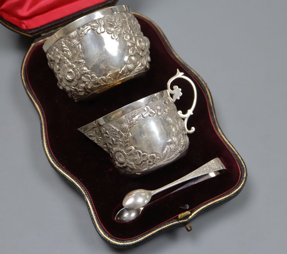 A cased late Victorian embossed silver cream jug, sugar bowl and pair of tongs, by Goldsmiths &