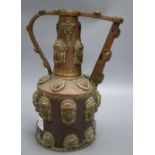 A Middle Eastern copper pot, decorated with classical ladies and lions faces with turquoise beaded