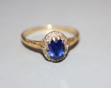 An 18ct, sapphire and diamond set oval cluster ring, size T, gross 3.2 grams.CONDITION: Needs a good