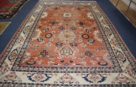 A large Persian pink ground carpet, woven with medallions and stylised flowers and leaves, approx.