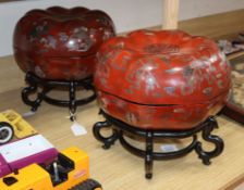 A pair of Chinese red lacquer melon form lidded boxes, on hardwood stands, height 30cm