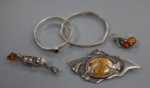 Two amber set brooches, one silver, two silver bangles and a 925 and hardstone set modernist brooch,