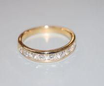 A modern 18ct gold and channel set nine stone diamond half eternity ring, with two smaller