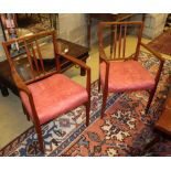 A pair of Gordon Russell teak elbow chairs