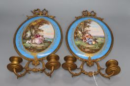 A pair of gilt brass two branch wall sconces with oval Sevres style plaques, length 40cmCONDITION: