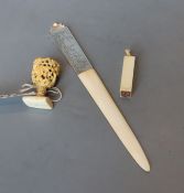An ivory carving, an ivory seal and an ivory page turner, the handle marked sterling silver, all