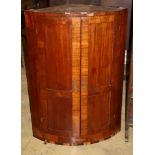 A Regency banded mahogany bow fronted hanging corner cupboard (a.f.), W.70cm, D.44cm, H.100cm