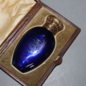 A Victorian engraved gilt white metal mounted blue glass scent bottle, in fitted case, 85mm.