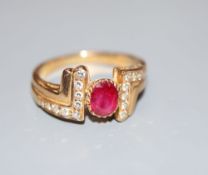 A modern 750 yellow metal, ruby and diamond dress ring, size M, gross 4.8 grams.CONDITION: No