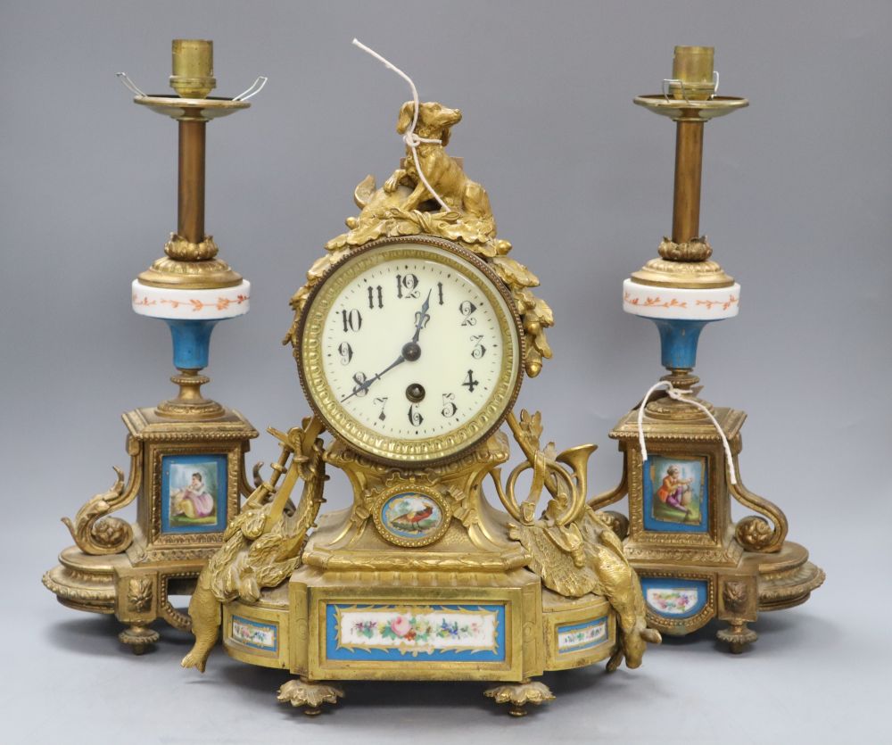 A 19th century French Louis XVI style ormolu mantel clock and a pair of associated spelter table