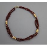 A modern gilt metal mounted and rough cut garnet bead triple strand necklace, 47cm.
