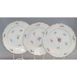 Three Meissen floral and gilt decorated plates, diameter 24cmCONDITION: One dish has a large area of