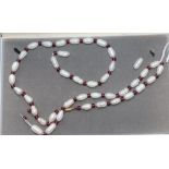 A modern single strand river baroque pearl and garnet bead necklace, (string broken), 63.5cm.