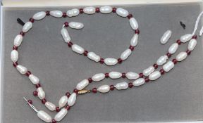 A modern single strand river baroque pearl and garnet bead necklace, (string broken), 63.5cm.