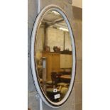 An oval white painted silvered frame bevelled wall mirror, W.72cm, H.47cm