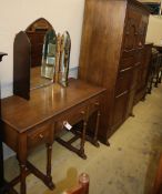 A carved and panelled oak wardrobe fitted two doors with matching compactum and dressing table,