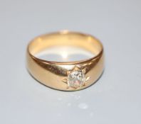 A late Victorian yellow metal and gypsy set solitaire diamond ring, size R, gross 7 grams.CONDITION: