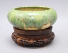 A Chinese green and straw-coloured crackle glaze brushwasher, Qing dynasty hongmu stand, height 13cm