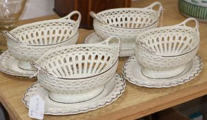 A pair of late 18th century creamware chestnut baskets and stands, a similar pair of baskets with