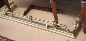 An Edwardian brass ball and claw fire kerb, L.136cm