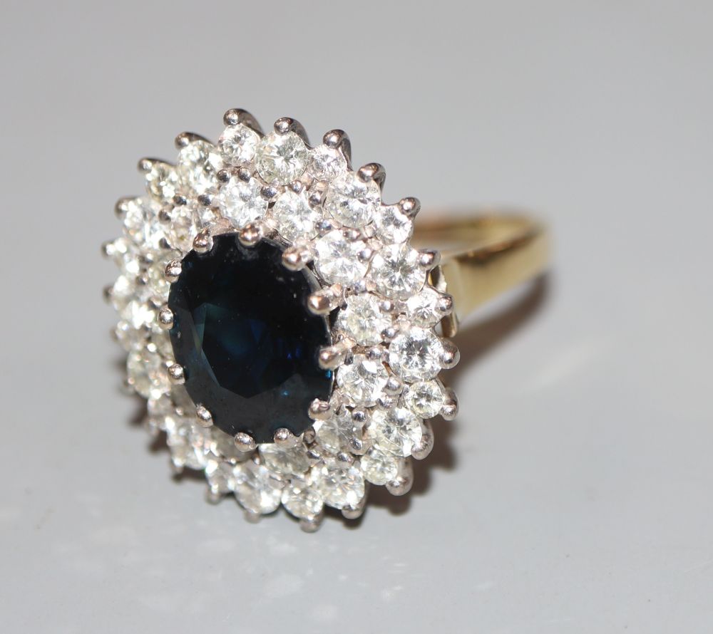 A modern 18ct gold, sapphire and diamond set oval cluster ring, size L, gross 7 grams.CONDITION: