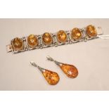 A white metal and amber cabochon set bracelet, 17cm and a pair of similar drop earrings, 6cm.