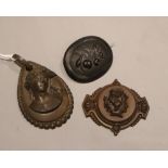 Two carved brooches and a carved pendant, largest 64mm, (one fitting missing).