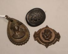 Two carved brooches and a carved pendant, largest 64mm, (one fitting missing).