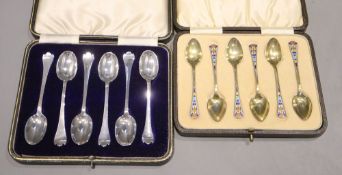 Two cased sets of six silver teaspoons/coffee spoons including silver gilt and enamel by Levi &