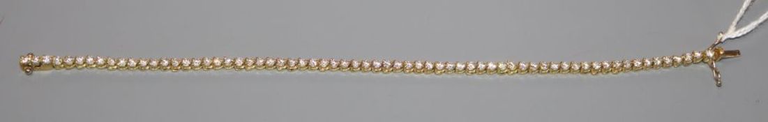 A modern 750 yellow metal and diamond set line bracelet, 18.5cm, gross 10.6 grams.CONDITION: Overall