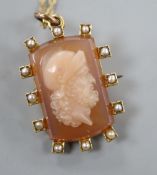 A late Victorian yellow metal and split pearl mounted hardstone cameo pendant brooch, carved with