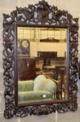 A 19th century Black Forest rectangular carved oak wall mirror decorated with birds amongst fruiting