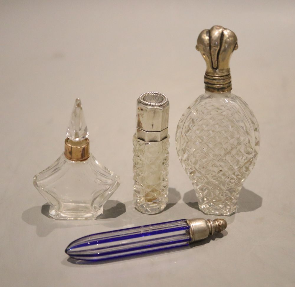 Four assorted early 20th century scent bottles including two white metal mounted and one 9ct gold