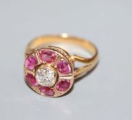 A late 19th/early 20th century yellow metal, ruby and diamond set circular cluster ring, size J,