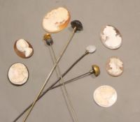 Four assorted mounted metal hatpins including amethyst and six carved cameo shells, five