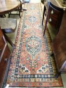 A Persian red ground runner, c.1860, 460 x 100cmCONDITION: Worn and faded throughout, with some