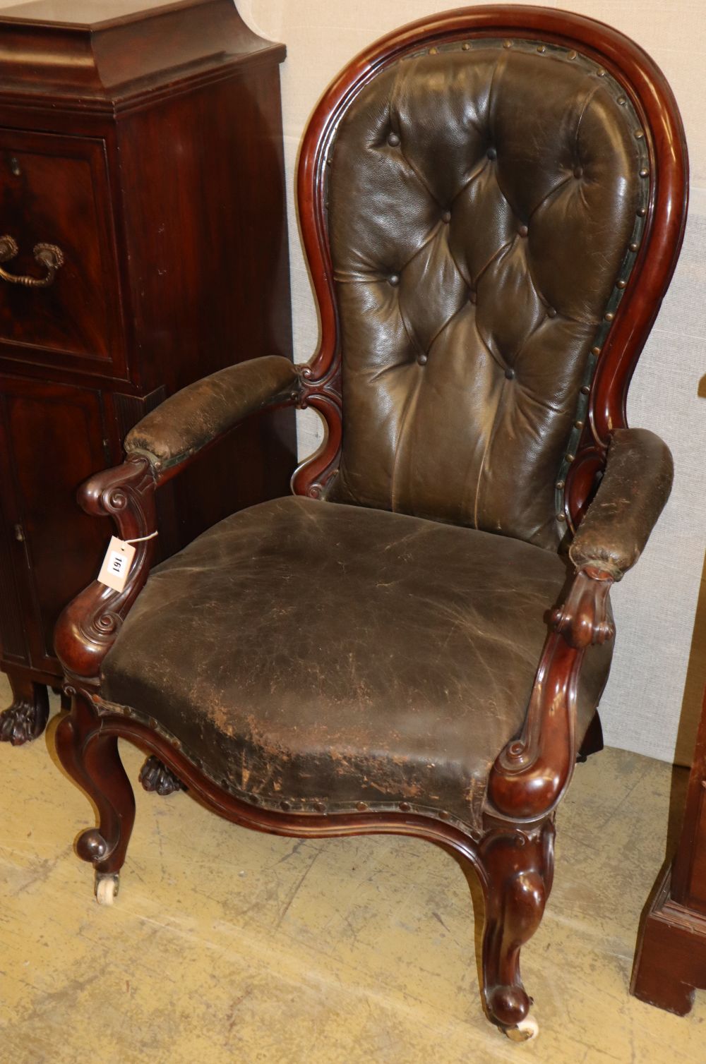 A Victorian black leather upholstered armchair, c.1860CONDITION: There are a few dents to the