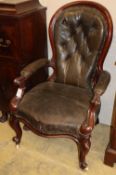 A Victorian black leather upholstered armchair, c.1860CONDITION: There are a few dents to the