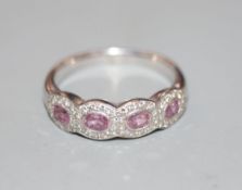 A modern 18ct white gold, pink sapphire and diamond set quadruple cluster ring, size R, gross 5.8