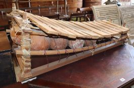 A Chinese wooden and terracotta xylophone, L.110cm