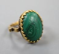 An 18k and oval cabochon malachite set dress ring, size N, gross 7.1 grams.CONDITION: Surface