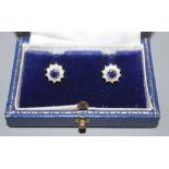 A modern pair of 18ct white gold, sapphire and diamond set circular cluster rings, 9mm, gross 3.2