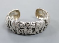 A modern white metal bangle modelled as a heard of elephants by Patrick Mavros, signed and dated