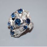 A 1970's? textured 18ct, sapphire and diamond cluster dress ring, in a raised setting, size P, gross