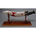 A decorative model of a kukri on stand