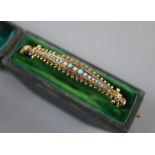 A late Victorian 9ct, turquoise and seed pearl set hinged bangle, in fitted box, gross 6.7 grams.