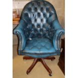 A buttoned blue leather upholstered swivel desk chair